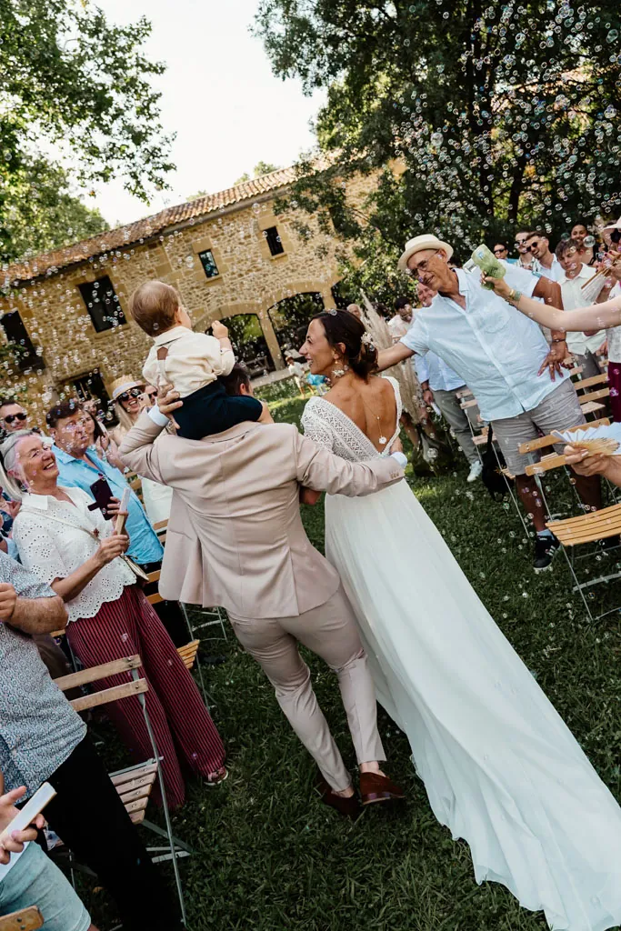 Sortie de cérémonie des mariés devant leurs invités, dans le parc d’une bastide