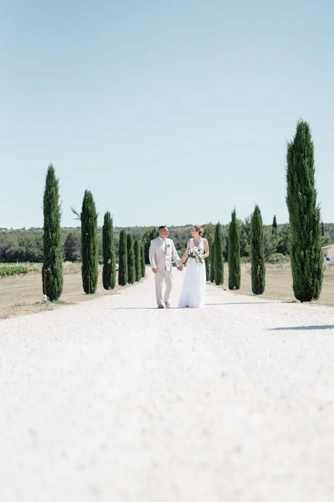 Les mariés au bout d’une allée de cyprès, sous le soleil de Provence